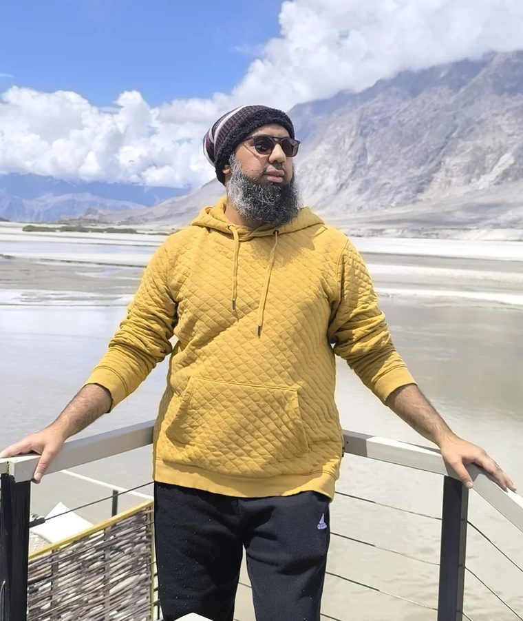 Muhammad Ahsan on a river deck below the mountains at Skardu, northern Pakistan